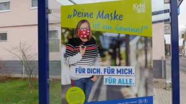 11 Aralık 2021 - Kehl, Almanya: Otobüs durağında COVID19 'a karşı maske isteyen bir poster, Almanca yazı. Grip Coronavirus 'a karşı mücadeleyi önlemek.