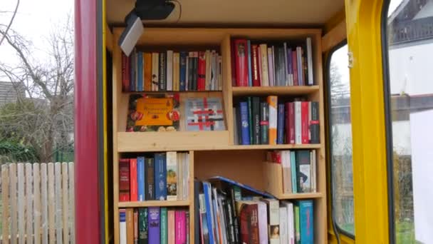 Дек 11, 2021 - Фелль, Германия: телефонная будка с большим количеством бесплатных книг для обмена. Концепция любителей книг. Литература на немецком — стоковое видео