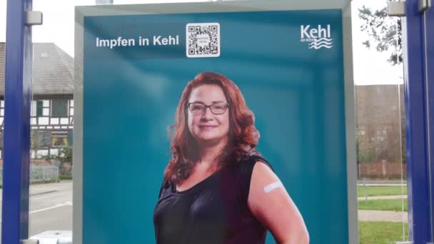 11 de dezembro de 2021 - Kehl, Alemanha: Um cartaz pedindo a vacina Covid19 em uma parada de ônibus, com uma inscrição em alemão, inglês e russo. Prevenção da luta contra o vírus da gripe — Vídeo de Stock