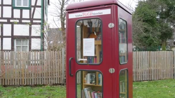 Dez 11, 2021 - Kehl, Alemanha: Uma cabine telefônica contendo muitos livros gratuitos para trocar. Conceito de amantes de livros. Literatura em alemão — Vídeo de Stock