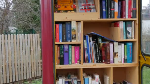 Dez 11, 2021 - Kehl, Alemanha: Uma cabine telefônica contendo muitos livros gratuitos para trocar. Conceito de amantes de livros. Literatura em alemão — Vídeo de Stock