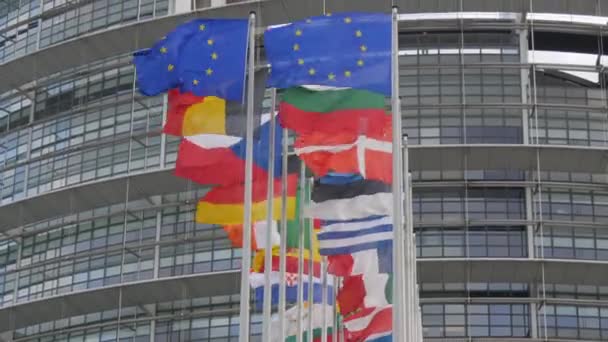 7 de dezembro de 2021 Estrasburgo, França: Edifício do Parlamento Europeu. Bandeiras de países europeus acenando com o edifício sede do Parlamento Europeu em segundo plano inclui Reino Unido — Vídeo de Stock