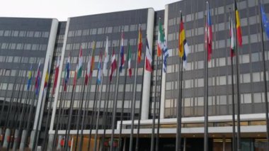 7 Aralık 2021 - Strasbourg, Fransa: Avrupa Parlamento Binası. Arka planda Avrupa Parlamentosu genel merkez binası ile el sallayan Avrupa ülkelerinin bayrakları arasında İngiltere de yer alıyor