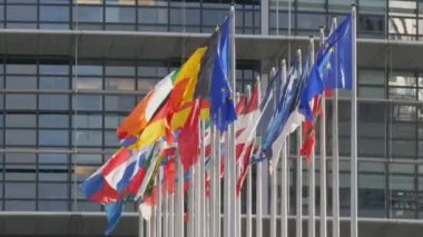 7 Aralık 2021 - Strasbourg, Fransa: Avrupa Parlamento Binası. Arka planda Avrupa Parlamentosu genel merkez binası ile el sallayan Avrupa ülkelerinin bayrakları arasında İngiltere de yer alıyor