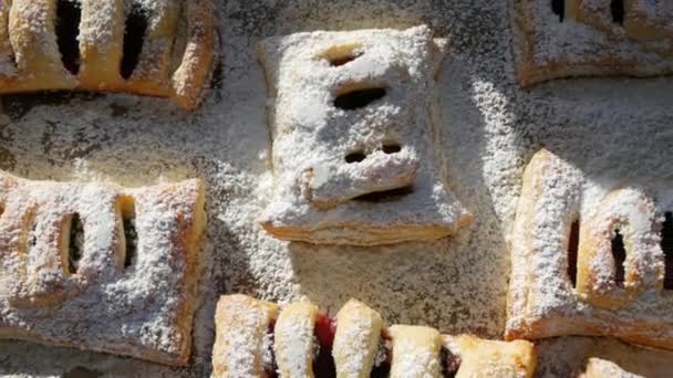 Kue buatan sendiri yang lezat. Puff pastry dengan ceri, murah hati ditaburi dengan icing gula di atas. Delicious roti segar close up view — Stok Video