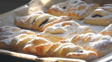 Lezzetli ev yapımı kekler. Kirazlı puf böreği, üzerine bol bol şeker serpiştirilmiş. Lezzetli taze çörekler. Yakın görüş.