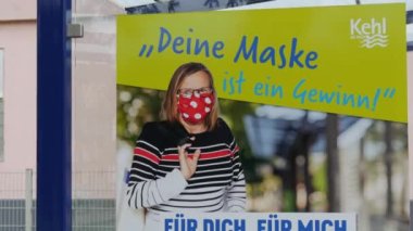 11 Aralık 2021 - Kehl, Almanya: Otobüs durağında COVID19 'a karşı maske isteyen bir poster, Almanca yazı. Grip Coronavirus 'a karşı mücadeleyi önlemek.