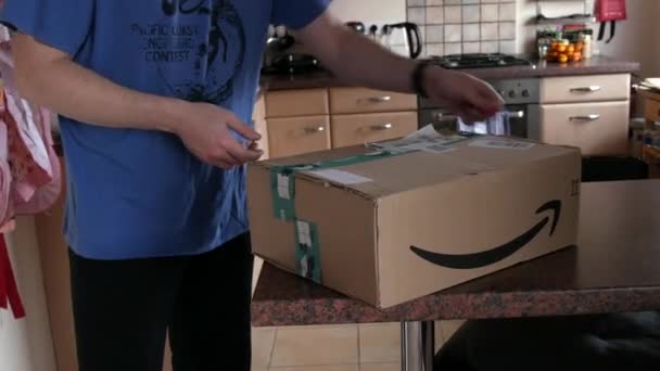9 грудня 2021 р. - Кел, Німеччина: чоловік розпаковує велику пачку доставленого товару. Box from the Amazon online store — стокове відео