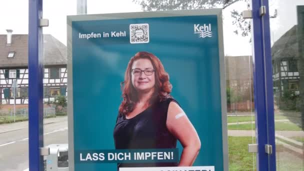 11 грудня 2021 - Кел, Німеччина: плакат із закликом вакцини Covid19 на автобусній зупинці, з написом німецькою, англійською та російською мовами. Профілактика боротьби з вірусом грипу — стокове відео