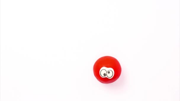 A funny bouncing red ball with eyes on a white background. Stopmotion animation, plasticine claymotion — Stock Video