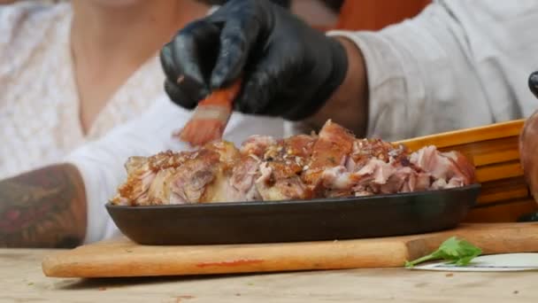 The chef greases the finished chopped pork shank meat and is ready to serve to guests at the food festival