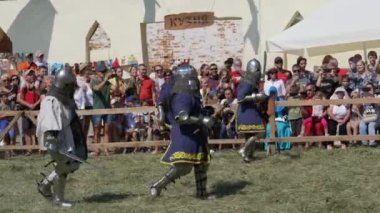 Trostyanetler, Ukrayna - 21 Ağustos 2021: Seyirciler ortaçağ savaşlarının çoğalmasına ilgi gösteriyorlar. Şövalye zırhı ve metal miğferler ve kalkanlar giymiş insanlar soğuk çelikle savaşıyor.