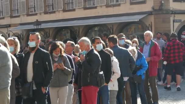 10 de outubro de 2021 Estrasburgo, França: uma multidão de pessoas de diferentes idades, de jovens a idosos, em máscaras médicas de proteção, está na fila. Distância vs COVID-19 — Vídeo de Stock