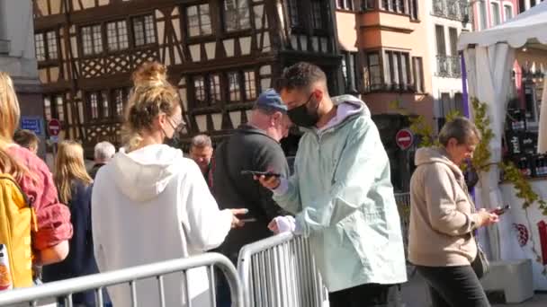 10 Ekim 2021 - Strasbourg, Fransa: Özel e-yeşil aşı e-pasaportlarıyla fuara giriş. Çitlerin önündeki girişteki güvenlik görevlisi covid-19 aşılarını kontrol ediyor. — Stok video