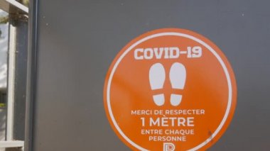 Yazı Fransızcada. COVID-19 nedeniyle tramvay durağında mesafe uyarısı.
