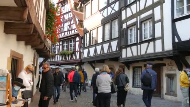 10 oktober 2021 - Strasbourg, Frankrike: Den gamla stadsdelen Strasbourg, Petite France, turister promenera på gatorna och inspektera husen i fachwerk halvtimrad stil — Stockvideo
