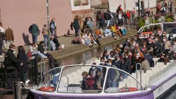 10 oktober 2021 - Straatsburg, Frankrijk: Een toeristenboot op de rivier de Ile met veel toeristen aan boord die beschermende medische maskers dragen tegen covid-19. De boot landt aan de kust — Stockvideo