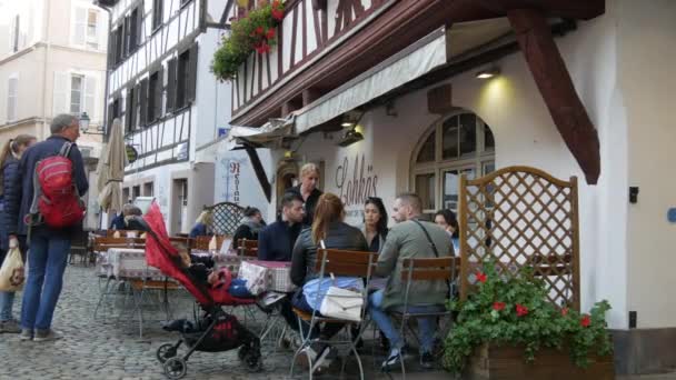 10 Ekim 2021 - Strasbourg, Fransa: Strasbourg 'un eski çeyreği, Petite France, turistler sokaklarda dolaşıyor ve fachwerk' teki evleri yarı kereste tarzında teftiş ediyorlar — Stok video