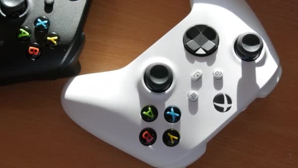 2021年12月9日- -德国基尔：在游戏主机白色微软Xbox系列S游戏控制器前的桌子上，有两个黑白的控制杆，最新的无线游戏面板和控制杆。 — 图库视频影像