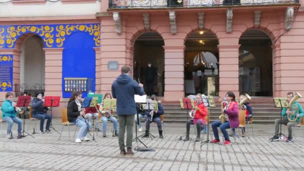 Gengenbach, Almanya - 15 Aralık 2021: Çocuk orkestrası sokakta, binanın önünde farklı müzik aletleri çalıyor, ana hocayı dinliyor — Stok video