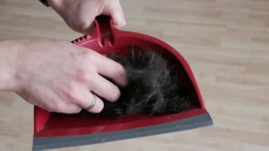 Kırmızı kepçeyle kesilmiş bir sürü erkek saçı var. Adam elleriyle yeni kesilmiş saçına dokunuyor.