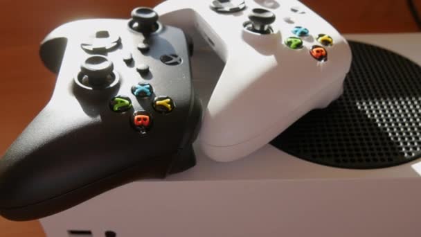 9 de diciembre de 2021 - Kehl, Alemania: Dos joysticks en blanco y negro sobre la mesa frente a la consola de juegos White Microsoft Xbox Series S Game Controller, El nuevo mando inalámbrico, joysticks para — Vídeo de stock