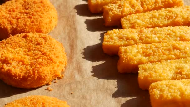 Queijo de camembert em massa em um alpendre com uma assadeira ao lado de palitos de peixe em massa. Preparação rápida de alimentos — Vídeo de Stock