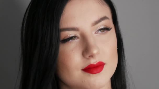 Vista de cerca de modelo hermosa chica con labios grandes pintados con lápiz labial rojo. Mujer joven posando con maquillaje de noche brillante — Vídeo de stock