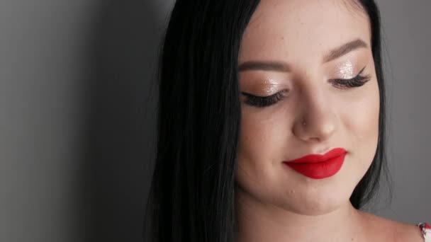 Vista de cerca de modelo hermosa chica con labios grandes pintados con lápiz labial rojo. Mujer joven posando con maquillaje de noche brillante — Vídeos de Stock