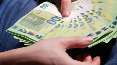 Adam 50 ve 100 Euro 'luk banknot hayranı sayıyor. Avro paralarını sayan işadamları. Para kazanan, ekonomi konsepti, Avro para birimi faturaları. Para nakit, mali hesaplamalar. Kapat.