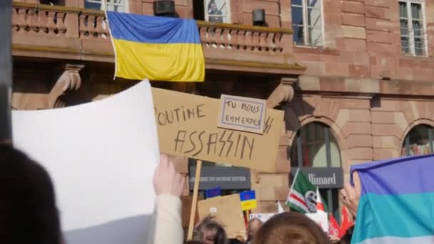 Страсбург, Франция - 26 февраля 2022 года: Люди с украинскими флагами и плакатами протестуют против войны на Украине. Демонстрация против войны между Украиной и Россией. Протесты против Путина — стоковое видео