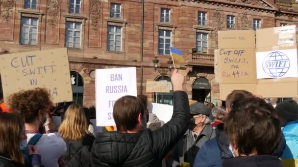 Strasbourg, Fransa - 26 Şubat 2022: Ukrayna bayrakları ve posterleri olan insanlar Ukrayna 'daki savaşı protesto ediyorlar. Ukrayna ve Rusya arasındaki savaşa karşı bir gösteri. Putin 'e karşı protesto — Stok video