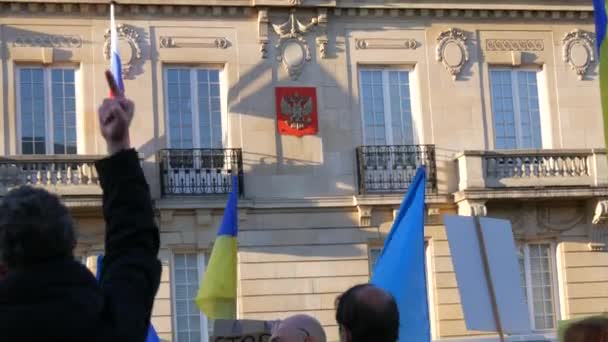 2022年2月26日-フランス・ストラスブール:ロシア連邦大使館前で、ウクライナとロシアの間の戦争に抗議するウクライナ国旗とプラカードを持つ人々が立つ。男は指のジェスチャーを示す — ストック動画