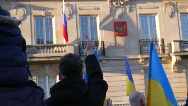 Strasbourg, France - 26 février 2022 : Des gens avec des drapeaux et des pancartes ukrainiens protestent contre la guerre entre l'Ukraine et la Russie devant l'ambassade de la Fédération de Russie. Homme montrer geste du doigt — Video