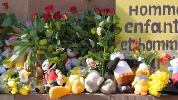 Straatsburg, Frankrijk - 26 maart 2022: Demonstratie ter ondersteuning van Oekraïne tegen de oorlog met Rusland. Gedenkteken voor vermoorde kinderen uit Oekraïne met speelgoed en bloemen. Franse inscriptie — Stockvideo