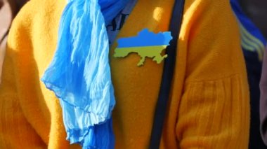Strasbourg, Fransa - 26 Mart 2022: Rusya ile savaşa karşı Ukrayna 'yı destekleyen gösteri. Bir kadın Ukrayna 'nın sembolü olarak göğsünde bir rozetle savaşa karşı bir konuşma yapıyor.