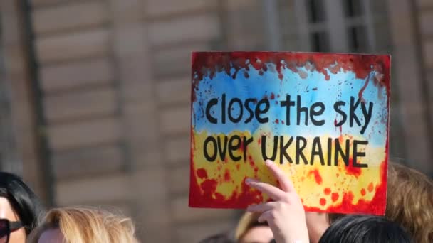 Straßburg, Frankreich - 26. März 2022: Demonstration zur Unterstützung der Ukraine gegen den Krieg mit Russland. Ein Schild in den Händen mit einem Aufruf an die NATO, den Himmel über der Ukraine zu schließen — Stockvideo