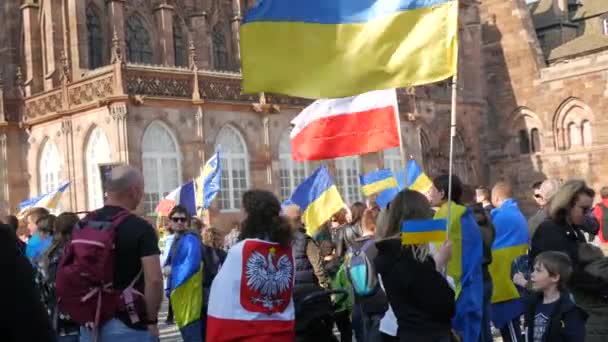 Estrasburgo, Francia - 26 de marzo de 2022: Manifestación en apoyo de Ucrania contra la guerra con Rusia. Personas con banderas y disfraces nacionales sostienen afiches contra la guerra — Vídeos de Stock