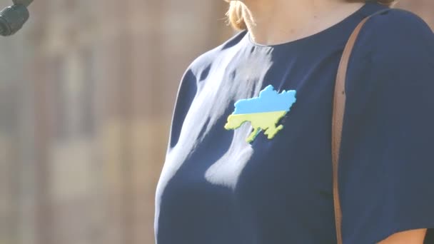 2022年3月26日-フランス・ストラスブール、ロシアとの戦争に対するウクライナの支援デモ。女性はウクライナのシンボルで胸にバッジとの戦争に対するスピーチを行います — ストック動画