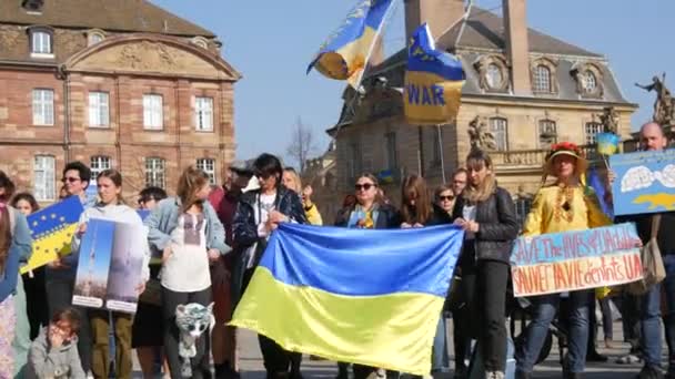 Estrasburgo, Francia - 26 de marzo de 2022: Manifestación en apoyo de Ucrania contra la guerra con Rusia. Personas con banderas y disfraces nacionales sostienen afiches contra la guerra — Vídeos de Stock