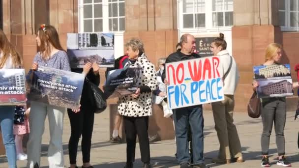 Estrasburgo, Francia - 26 de marzo de 2022: Manifestación en apoyo de Ucrania contra la guerra con Rusia. Personas con banderas y disfraces nacionales sostienen afiches contra la guerra — Vídeo de stock