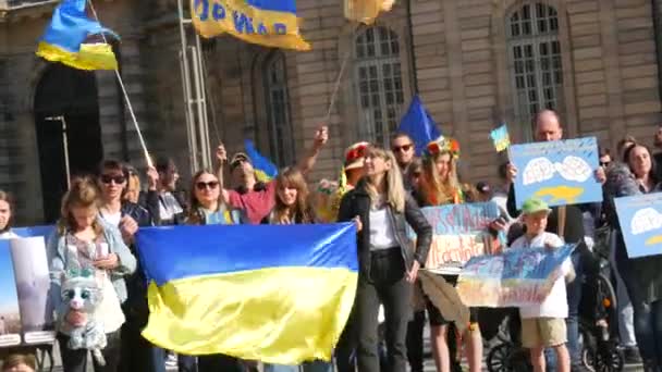 Štrasburk, Francie - 26. března 2022: Demonstrace na podporu Ukrajiny proti válce s Ruskem. Lidé s vlajkami a v národních kostýmech mají protiválečné plakáty — Stock video