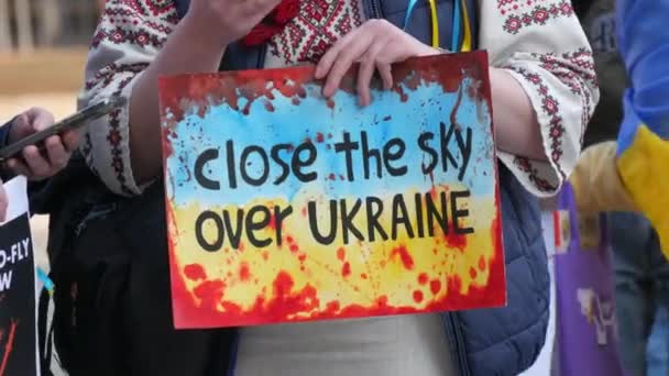 Straßburg, Frankreich - 26. März 2022: Demonstration zur Unterstützung der Ukraine gegen den Krieg mit Russland. Ein Schild in den Händen mit einem Aufruf an die NATO, den Himmel über der Ukraine zu schließen — Stockvideo