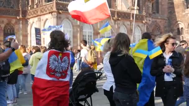 Straatsburg, Frankrijk - 26 maart 2022: Demonstratie ter ondersteuning van Oekraïne tegen de oorlog met Rusland. Mensen met vlaggen en in nationale kostuums hangen anti-oorlogsaffiches — Stockvideo