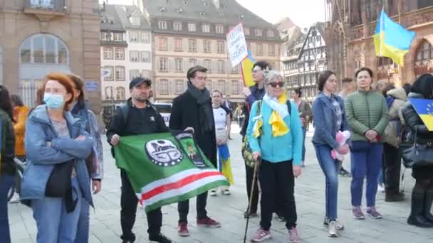 Strasbourg, Franciaország - 2022. március 26.: Az Oroszországgal vívott háború elleni ukrajnai tüntetés. Az emberek zászlókkal és nemzeti jelmezekben háborúellenes plakátokat tartanak. — Stock videók