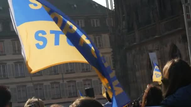 Страсбург, Франція - 26 березня 2022: Демонстрація на підтримку України проти війни з Росією. Українські прапори пурхають у вітрі з закликом зупинити війну, написану на них. — стокове відео