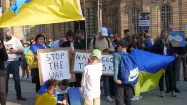 Strasbourg, Fransa - 26 Mart 2022: Rusya ile savaşa karşı Ukrayna 'yı destekleyen gösteri. Bayraklı ve ulusal kostümlü insanlarda savaş karşıtı posterler var.