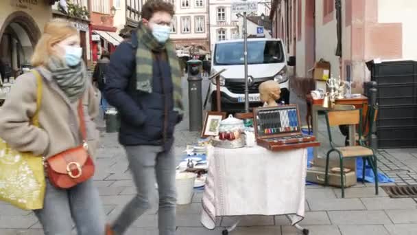 8 januari 2022 - Straatsburg, Frankrijk: Een antieke rommelmarkt in een Franse straat waar mensen en shoppers voorbij lopen. Veel oud gebruikt spul. — Stockvideo