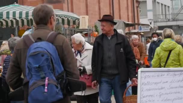 Кел, Німеччина - 29 жовтня 2021 року: люди прийшли на місцевий сільськогосподарський ринок, щоб купити різні сільськогосподарські продукти. Деякі відвідувачі носять медичні маски, інші - ні. — стокове відео