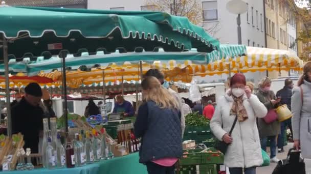 Kehl, Niemcy - 29 października 2021: Ludzie przybyli na lokalny rynek rolny, aby kupić różne produkty rolne. Niektórzy odwiedzający noszą maski medyczne, inni nie. — Wideo stockowe